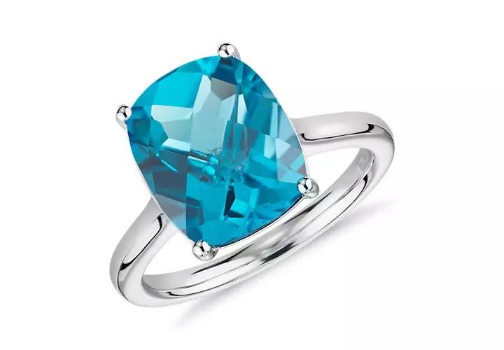 A cushion cut blue topaz engagement set in white gold