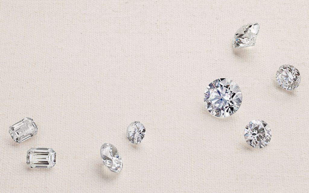 Loose diamonds of various shapes on a light background.