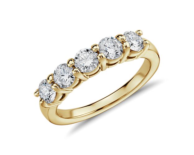 The Eternal five-stone diamond ring is just that, a timeless design that symbolizes a lasting love. Five round brilliant-cut diamonds weighing approximately 1-carat total weight sit securely in shared prongs spanning about 3/4-inch across the top of the ring. This enduring 14k yellow gold five-stone ring style is an incredibly wearable essential.