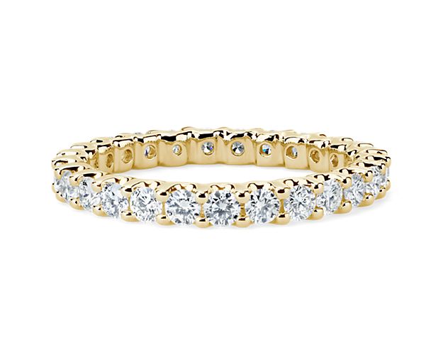 Brilliant in every way, this diamond eternity ring features round diamonds in a shared-prong and low-profile design of 14k yellow gold.