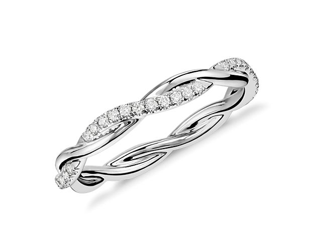 This beautiful and delicate wedding ring is formed by two intertwining bands, one of micropavé set diamonds and one of solid 14k white gold for an elegant statement.