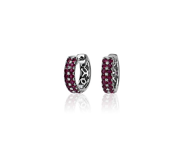 Two rows of sparkling rubies summon the eye to these beautiful huggie hoop earrings. They are designed in 14k white gold to ensure enduring quality and cool gleaming lustre.