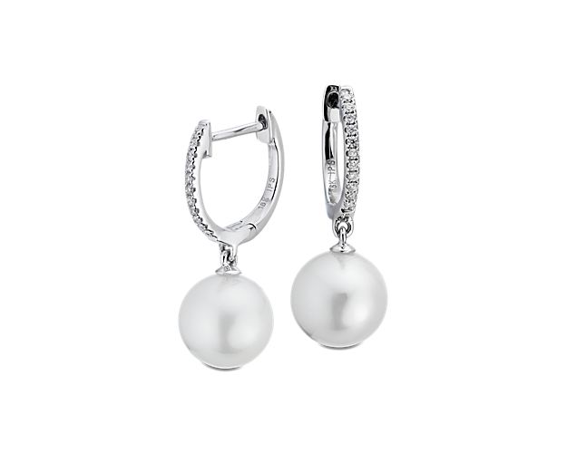 Luminous and sparkling, these South Sea cultured pearl and diamond hoop earrings are a perfect day-to-night pair. Two round white pearls are suspended from petite, pavé diamond hoops with a hinged back closure crafted in polished 18k white gold.