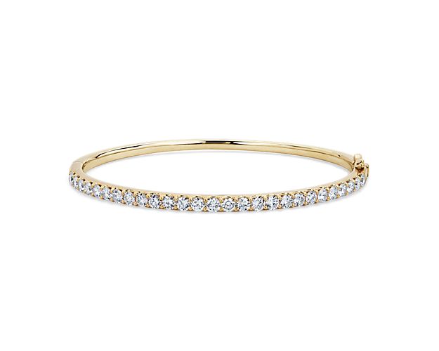 Add gorgeous gleam to your wrist with this round bangle bracelet crafted from warmly lustrous 14k yellow gold. Brilliant lab-grown diamonds encircle the bracelet, adding sparkling luxury.