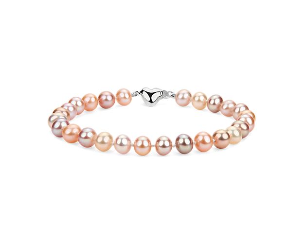 A strand of freshwater cultured pearls in varying hues of pink offers a fresh take on a classic style. Nearly round multicolor pearls are strung on a hand-knotted silk blend cord and completed with a sterling silver heart-shaped clasp.