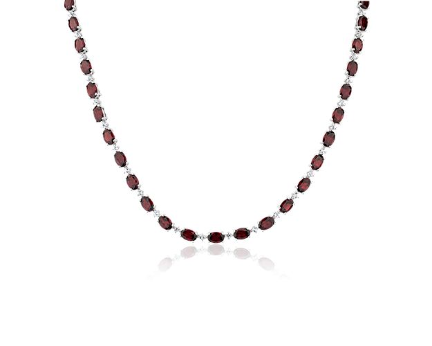 Shimmering oval-cut garnets sparkle along the length of this eternity necklace, adding elegant luxury to your look. The gleaming sterling silver setting promises lasting quality.