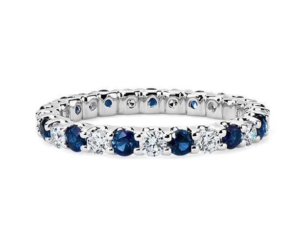 Brilliant and color-rich, this sapphire and diamond eternity ring features round sapphires and diamonds in a shared-prong design of 14k white gold.