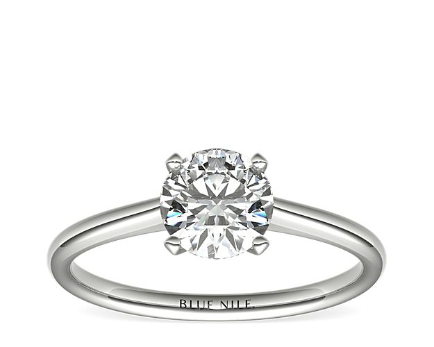 Elegant in simplicity, this petite nouveau solitaire engagement ring is crafted in polished 14k white gold to create a classic frame for your center diamond.