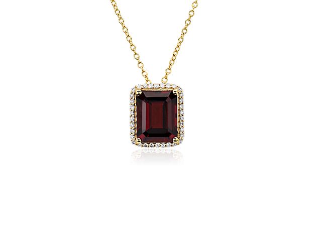 Embody elegance with this stately pendant necklace defined by a gorgeous emerald-cut garnet, surrounded by a shimmering halo. The rich tones of the stone are beautifully accented by the warm lustre of the 14k yellow gold.