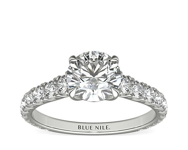 An expression of luxurious elegance, this platinum engagement ring highlights the center diamond that rests in a cathedral setting with scalloped pavé diamonds running down the sides of the band.