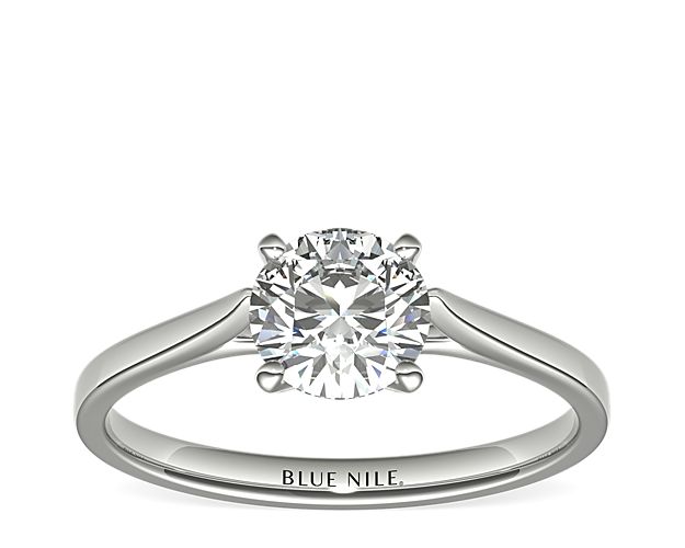 Delicate cathedral shoulders add classic elegance to this petite platinum solitaire engagement ring setting.