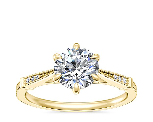 Promise your everlasting love with this gorgeous engagement ring crafted from gleaming 18k yellow gold. The six-prong design is elegantly accentuated by vintage-inspired milgrain detail and shimmering accent diamonds along the shank.