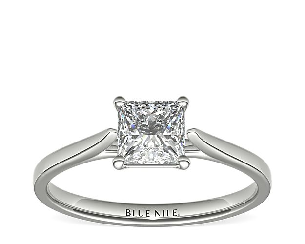 Delicate cathedral shoulders add classic elegance to this petite platinum solitaire engagement ring setting.