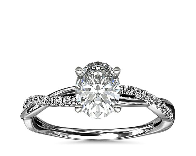 Classic with a twist, this platinum engagement ring features a delicate twist of pavé-set diamonds that will complement the center diamond of your choice.