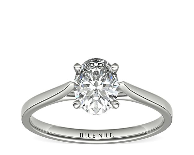 Delicate cathedral shoulders add classic elegance to this petite platinum solitaire engagement ring setting.