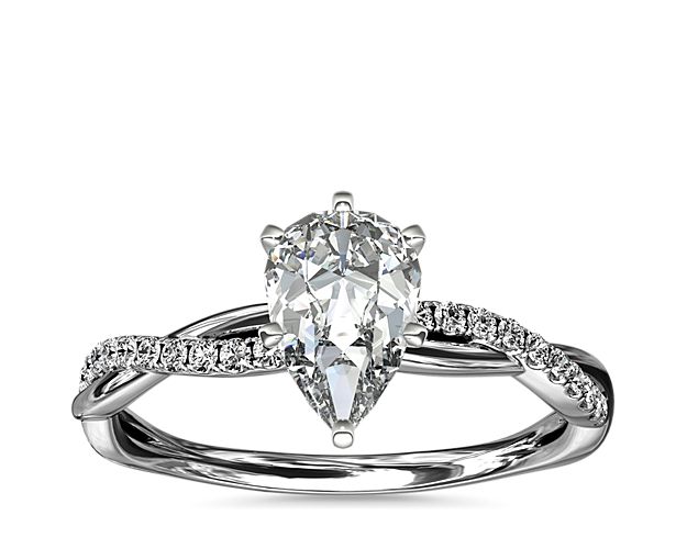 Classic with a twist, this platinum engagement ring features a delicate twist of pavé-set diamonds that will complement the center diamond of your choice.