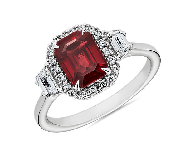 Flooded with light from V-shaped galleries, twin trapezoid-cut diamonds rest on either side of an emerald-cut ruby creating a sparkling display of light and color at the top of this 18k white gold ring.  This ring is accompanied by gemstone report #:JER2022100141303.