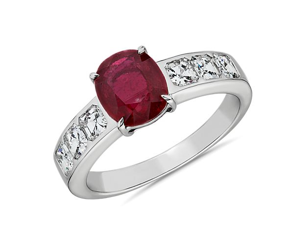 Adorned with Asscher-cut diamonds bezel-set along the side, this 18k white gold fashion ring embodies bold style with a medium red oval-cut ruby at its center.  This ring is accompanied by gemstone report #:CDC2001322.