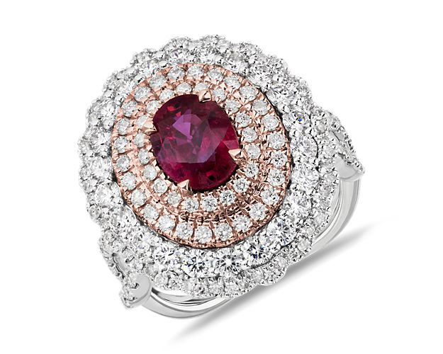 Set in 18k white and rose gold, this show-stopping ring features an oval-shaped ruby surrounded by four rows of sparkling diamond halos.