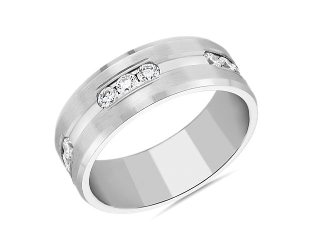 Diamonds gather in threes on this 14k white gold wedding band that has a center groove laid with channel-set stones.