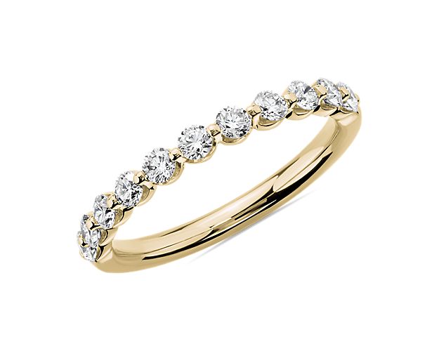 This sparkling wedding ring expresses timeless simplicity with breathtaking style as 1/2 ct. tw. of floating diamonds along the band catch the light for brilliant effect. The 14k yellow gold design promises classic luxury.