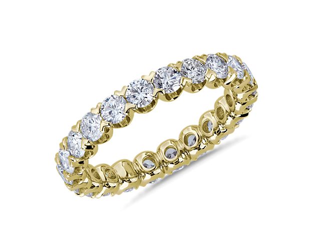 Brilliant diamonds endlessly encircle this stunning eternity ring crafted from 14k yellow gold. The V-prong pavé settings highlight the stones in elegantly contemporary style.