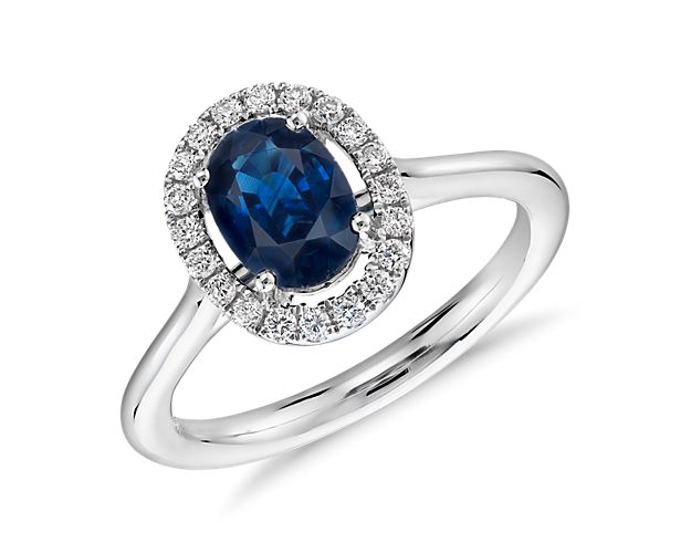 A true classic, this elegant oval sapphire and diamond halo ring can be for everyday or your engagement. Crafted in polished 14k white gold, it features a deep blue faceted sapphire surrounded by a glittering floating halo of petite round brilliant-cut diamonds on a slender band.