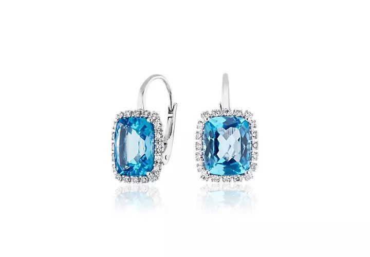 A pair of cushion-cut December birthstone earrings of Swiss Blue Topaz detailed with diamond halos set in white gold lever back drops