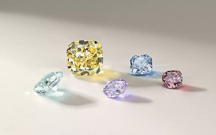 A group of colored diamonds featuring pale green, yellow, purple, blue and red stones